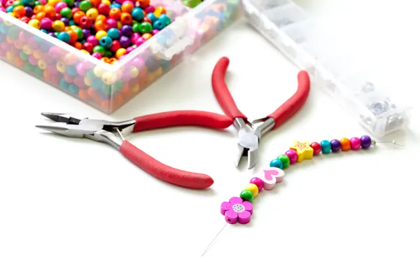 Bracelet made of plastic beads for girls unfinished in process of completing — Stock Photo, Image