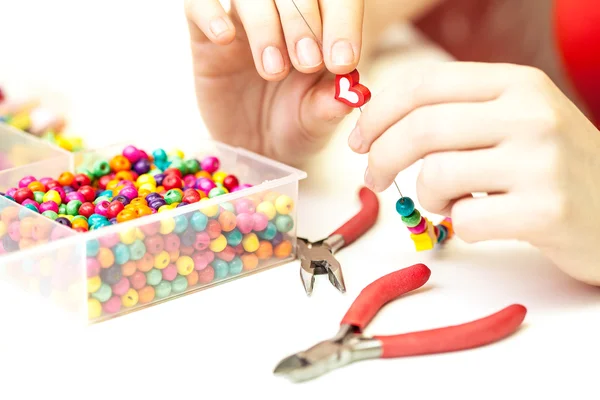 Mujer haciendo collar de cuentas de plástico de colores — Foto de Stock