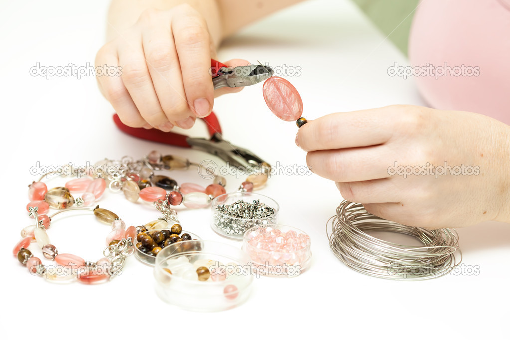 Woman making necklace from colorful plastic beads