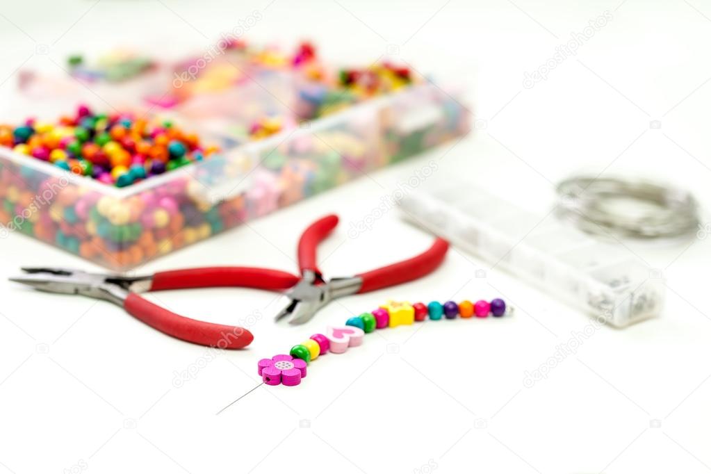 Bracelet made of plastic beads for girls unfinished in process of completing