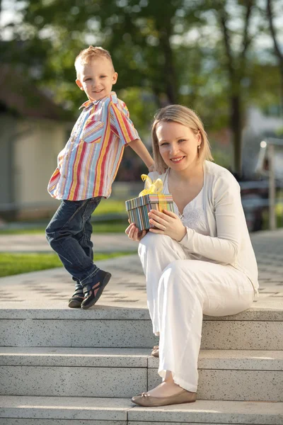 Beau garçon et maman au printemps avec cadeau. Fête des mères ou concept de célébration d'anniversaire — Photo