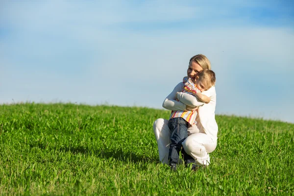 Beautiful boy and mom playing in spring park. Happy family concept. — Stock Photo, Image