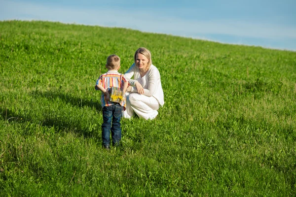 Beautiful boy and mom in spring with present. Mothers day or birthday celebration concept — Stock Photo, Image