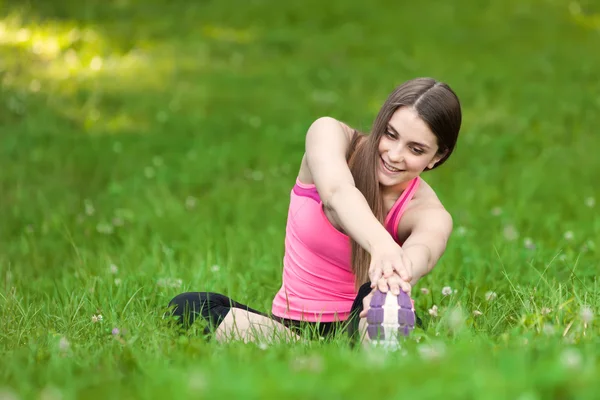 Gyönyörű fiatal nő csinál jóga gyakorlatok a parkban — Stock Fotó