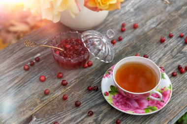 Güzel bir fincanda çay ve sonbahar bahçesinde kızılcık reçeli..