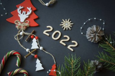Noel ve yeni yıl süslemeleri, şekerler ve meyveler ve ahşap yazılar Mutlu yıllar. 2022 yılının ahşap numaraları..