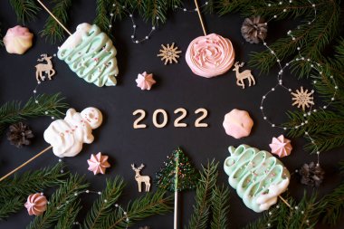 Noel ve yeni yıl süslemeleri, şekerler ve meyveler ve ahşap yazılar Mutlu yıllar. 2022 yılının ahşap numaraları..