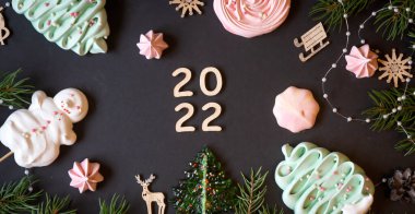 Noel ve yeni yıl süslemeleri, şekerler ve meyveler ve ahşap yazılar Mutlu yıllar. 2022 yılının ahşap numaraları..