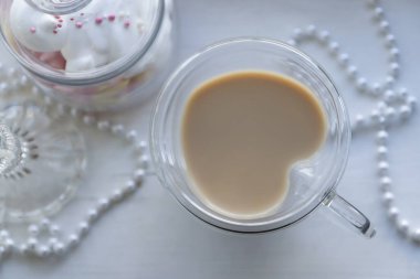 Kalp şeklinde bir kupa aromalı kahve ve pencere kenarında yeni yıl süslemeleri..