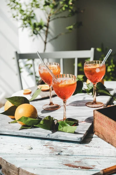 Aperol Spritz食前酒冷たい飲み物新鮮なオレンジとテーブルの上の灰色の大理石のボード上の氷とメガネで選択的な焦点 夏の爽やかなドリンクコンセプト — ストック写真