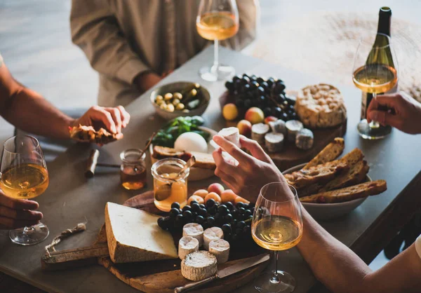 オレンジやローズワインを飲んでいる人々のグループは 具体的なテーブルの背景に会社のための様々なグルメスナックチーズブドウパンを食べる ワインの試飲会のコンセプト — ストック写真