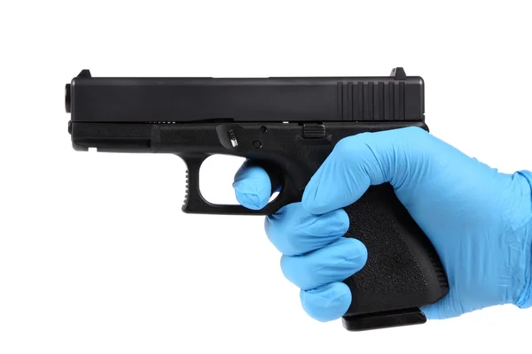 青い手袋で手は証拠として拳銃を保持します。 — ストック写真