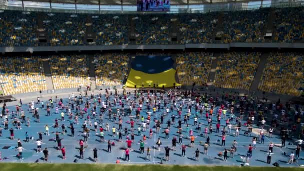 Légi felvétel egy drónról egy csoport embernek, akik tornával, aerobikkal és sporttal foglalkoznak. — Stock videók