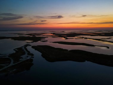 İnsansız hava aracından gün batımına kadar açık göl manzarası.