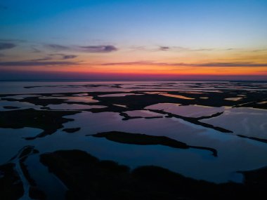 İnsansız hava aracından gün batımına kadar açık göl manzarası.