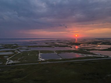 İnsansız hava aracından gün batımına kadar açık göl manzarası.