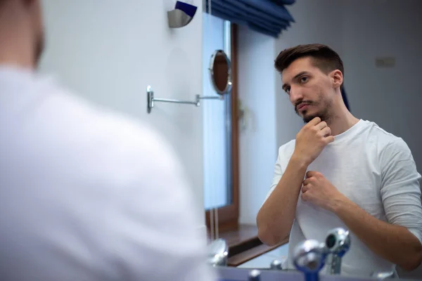 珍しい髭を生やした男が風呂鏡を見て感動した — ストック写真