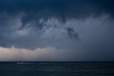 Fırtına sırasında bulutların arka planına karşı denizde tekne