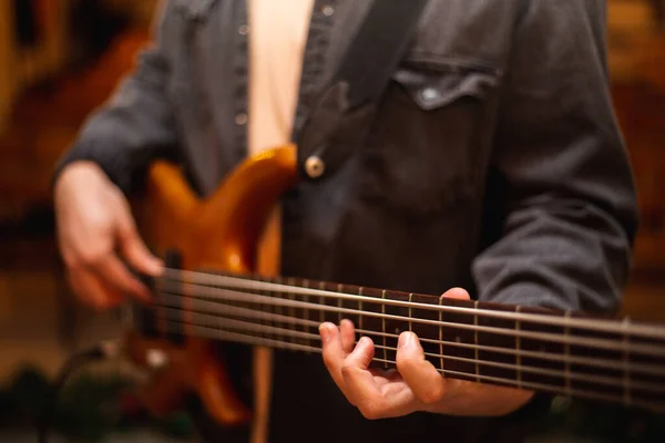 Молодий хлопець з бородою грає на бас-гітарі з п'ятьма струнами — стокове фото