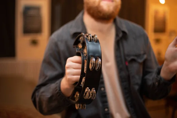 A young guy with a beard plays the tambourine — ストック写真