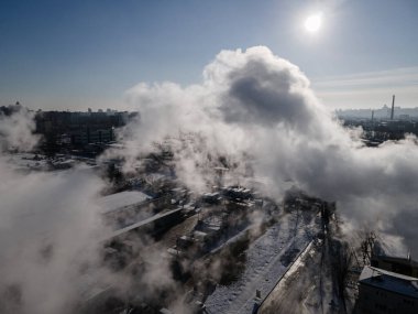 Aerial view from a drone to the factory and to air pollution in the city