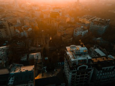 Gün batımında evlerin ve binaların çatısındaki İHA 'nın hava görüntüsü.