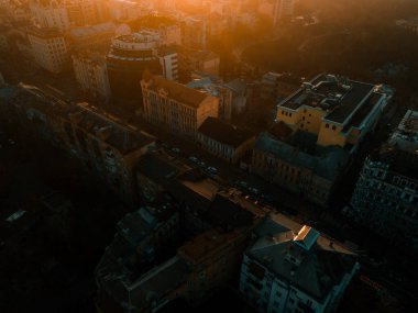 Gün batımında evlerin ve binaların çatısındaki İHA 'nın hava görüntüsü.