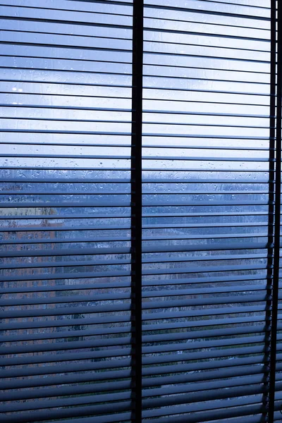 Tirai logam pada jendela dalam cuaca hujan — Stok Foto