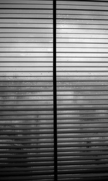 Fémredőnyök az ablakokon esős időben — Stock Fotó