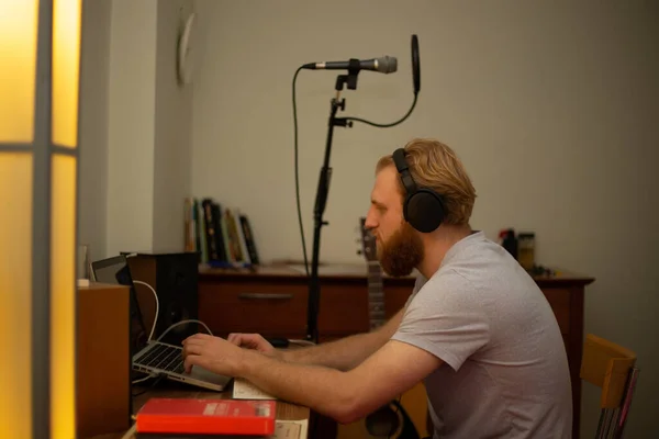 Ένας νεαρός με γενειάδα τραγουδάει σε ένα μικρόφωνο στούντιο με ποπ φίλτρο. — Φωτογραφία Αρχείου