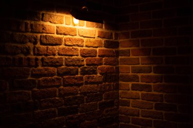 Brick wall illuminated by warm light from a lamp