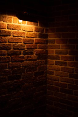 Brick wall illuminated by warm light from a lamp