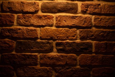 Brick wall illuminated by warm light from a lamp