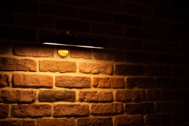 Brick wall illuminated by warm light from a lamp