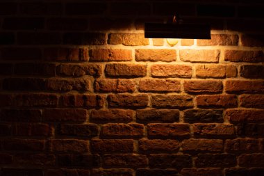 Brick wall illuminated by warm light from a lamp