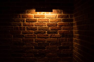 Brick wall illuminated by warm light from a lamp