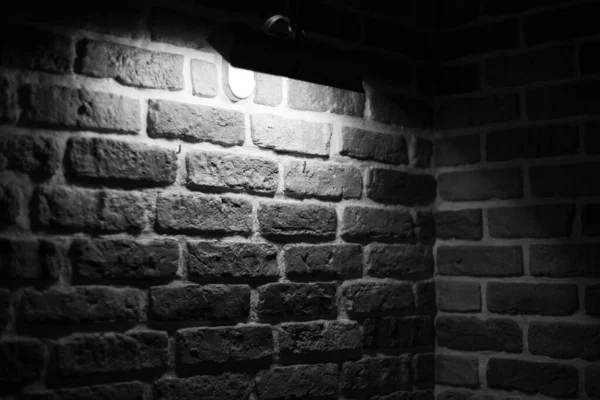 Brick wall illuminated by warm light from a lamp — 스톡 사진