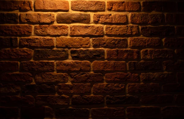 Brick wall illuminated by warm light from a lamp — Zdjęcie stockowe