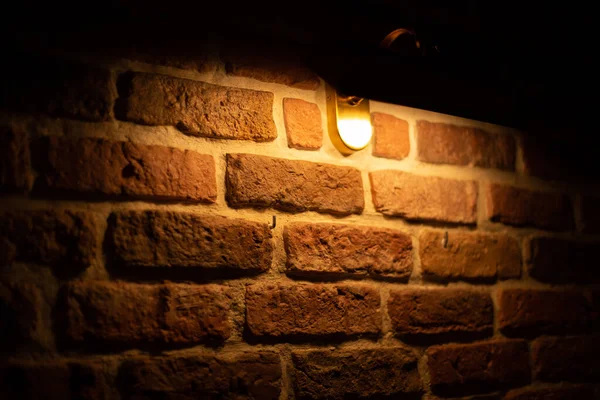 Pared de ladrillo iluminada por luz cálida de una lámpara —  Fotos de Stock