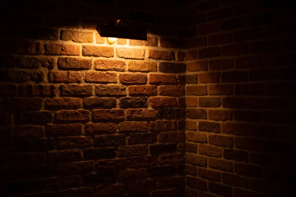 Brick wall illuminated by warm light from a lamp —  Fotos de Stock