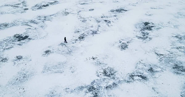 Légi kilátás felülről egy személy sétál egy jeges tó között télen — Stock Fotó