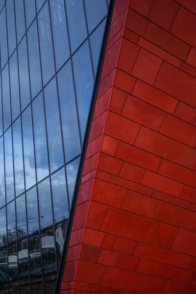 Modern arkitektur, raka och sneda linjer, röd färg på fasaden och en hel del glasering — Stockfoto