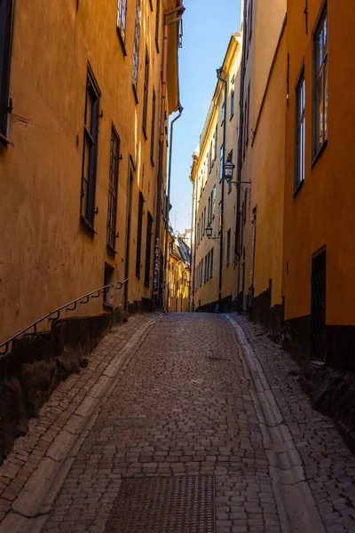 Calle estrecha en Europa en Estocolmo sin gente durante el día con una carretera pavimentada —  Fotos de Stock