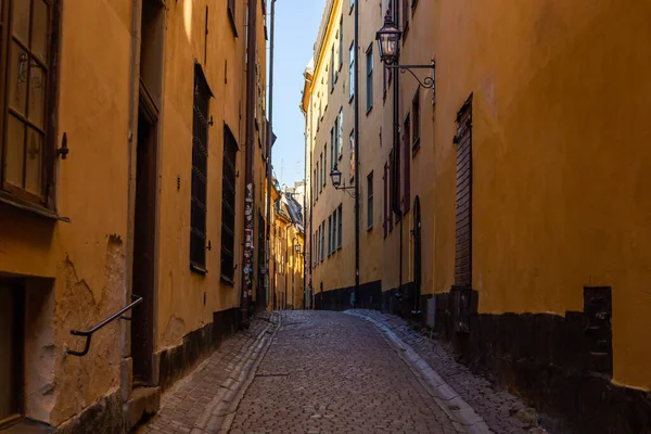 Calle estrecha en Europa en Estocolmo sin gente durante el día con una carretera pavimentada —  Fotos de Stock