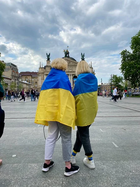 Lviv, Ukrayna 14.05.2022 - Ukrayna bayrağıyla kaplanmış iki Ukraynalı vatansever kadın birbirlerine yakın dururlar