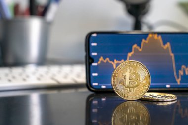 Borsa ve fintech konsepti. Bitcoin üzerine seçici odaklanma, ve odağını kaybetmiş borsası olan akıllı telefon.
