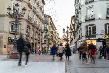 ZARAGOZA, İSPAN, 24 Ekim 2021. İnsanlar arka planda Bazilika del Pilar ile Alfonso I caddesinde alışveriş yapıyor ve turistik yerleri geziyor..