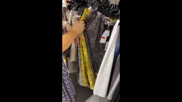 Vídeo Vertical Una Mujer Revisando Los Precios Ropa Una Tienda — Vídeos de Stock