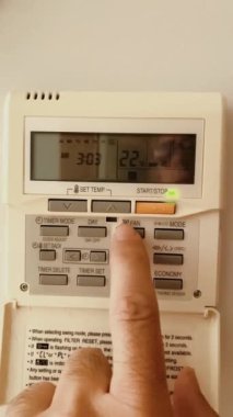 Isıtma termostatının ısısını düzenleyen bir adamın elinin ayrıntıları para tasarrufu için