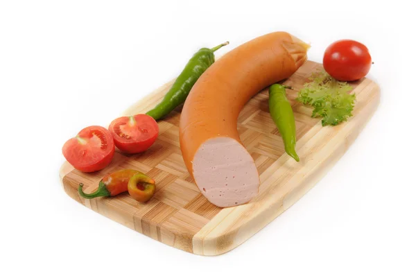 Sausages with a tomato and pepper on cutting board — Stock Photo, Image